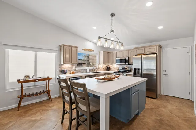 a kitchen with a table chairs refrigerator and cabinets