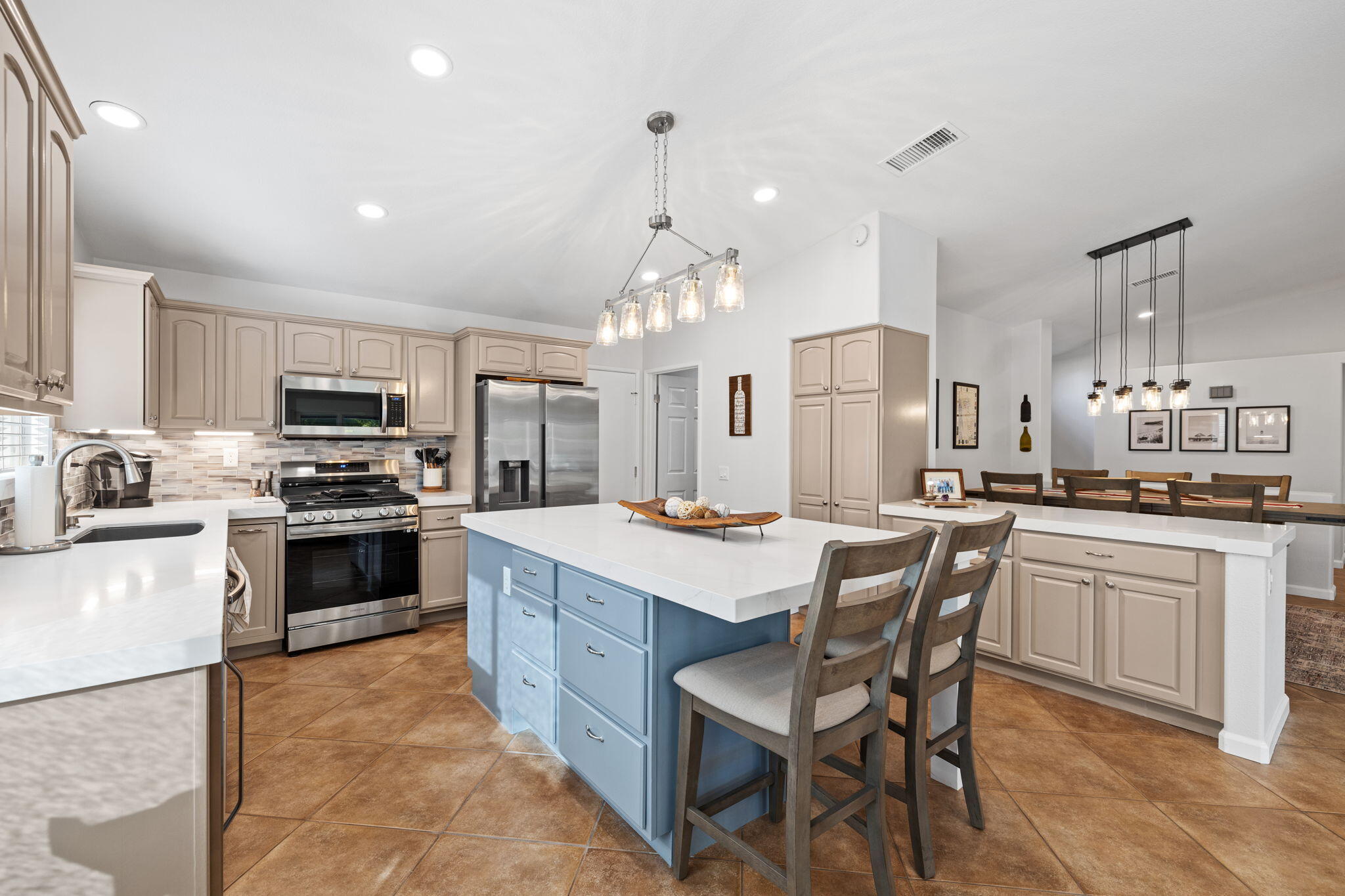 81107 Portola Circle Indio, CA 92201 - Photo 10 of 40 a kitchen with stainless steel appliances granite countertop a stove top oven a sink dishwasher a dining table and chairs with wooden floor