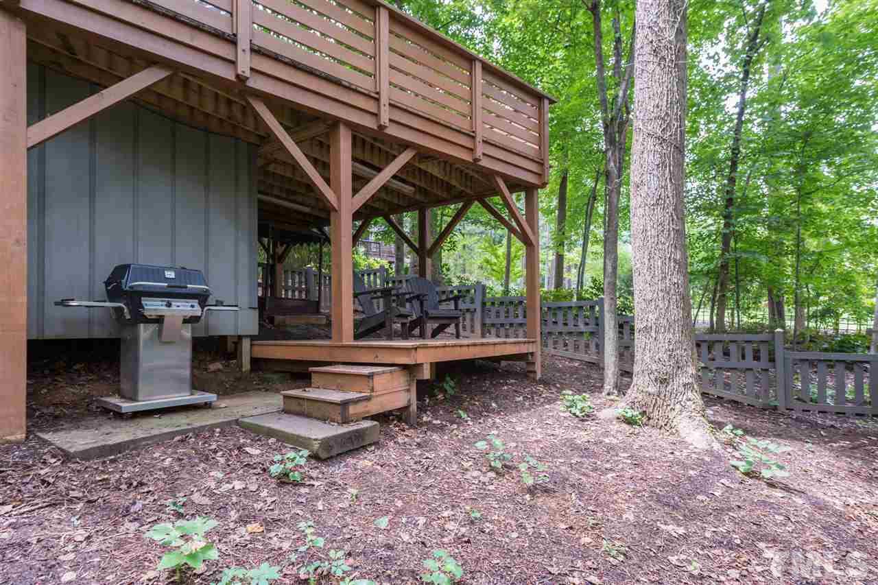 2733 Rue Sans Famille Raleigh, NC 27607 - Photo 23 of 25 a view of a patio with table and chairs under an umbrella