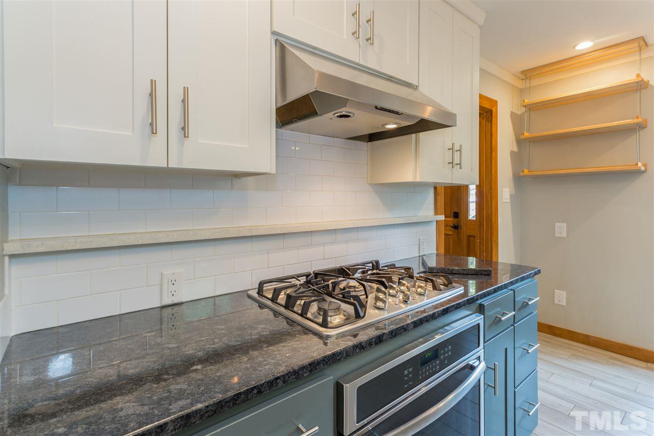 2733 Rue Sans Famille Raleigh, NC 27607 - Photo 8 of 25 a kitchen with stainless steel appliances granite countertop white cabinets and a stove