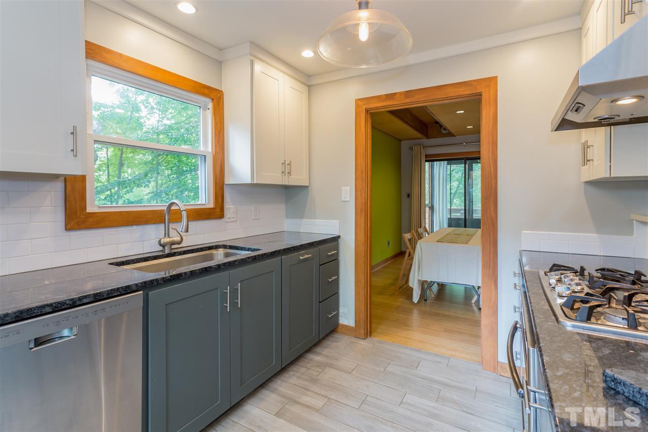 2733 Rue Sans Famille Raleigh, NC 27607 - Photo 9 of 25 a kitchen with stainless steel appliances granite countertop a sink and a stove