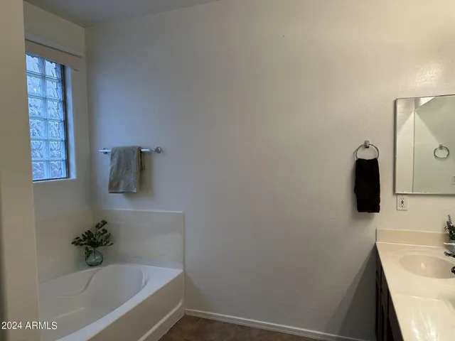 a bathroom with a tub sink and mirror