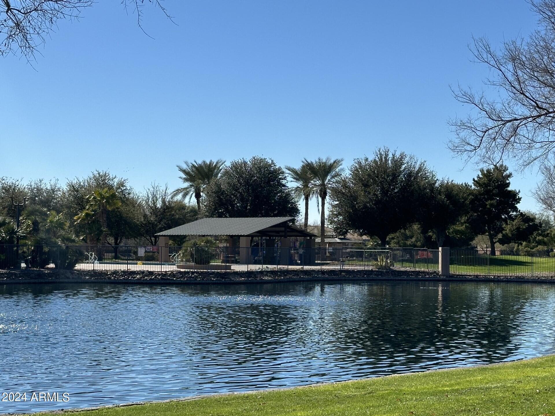 44456 West Eddie Way Maricopa, AZ 85138 - Photo 17 of 18 a view of a lake with a house in the background