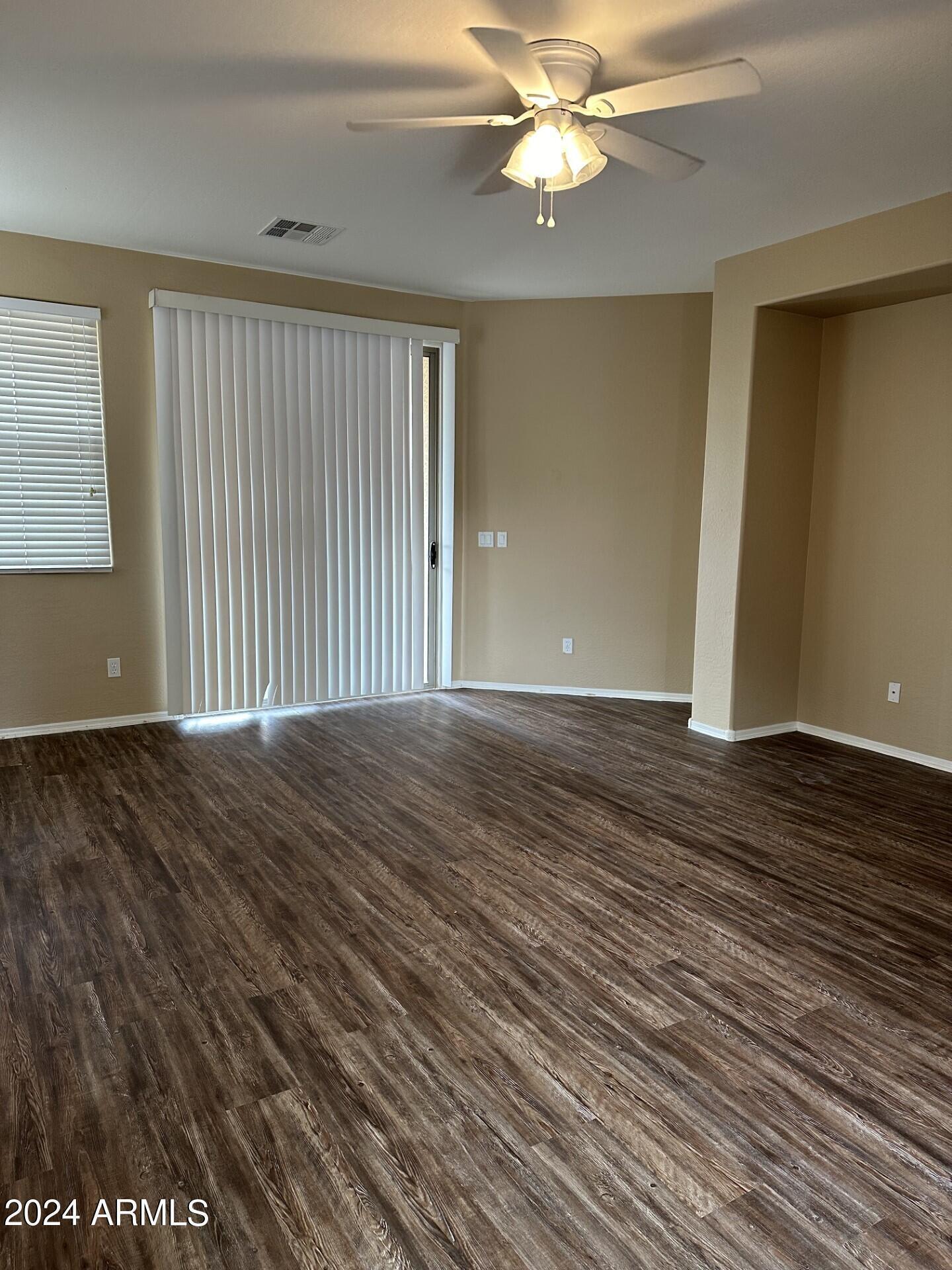 44456 West Eddie Way Maricopa, AZ 85138 - Photo 3 of 18 an empty room with wooden floor fan and windows