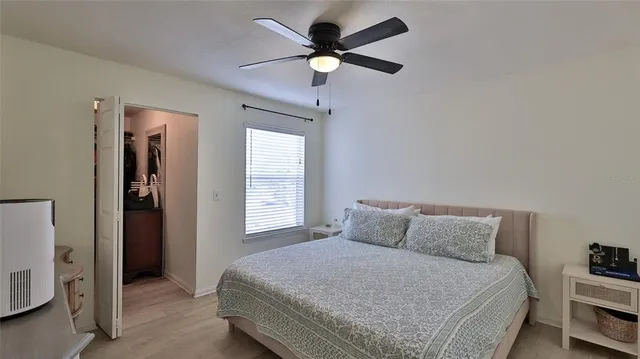 a bedroom with a bed and a ceiling fan