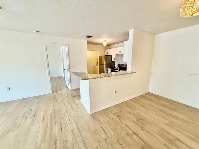 a view of a kitchen with kitchen island wooden floor and electronic appliances
