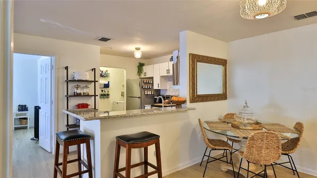 a kitchen with stainless steel appliances kitchen island granite countertop a refrigerator and cabinets