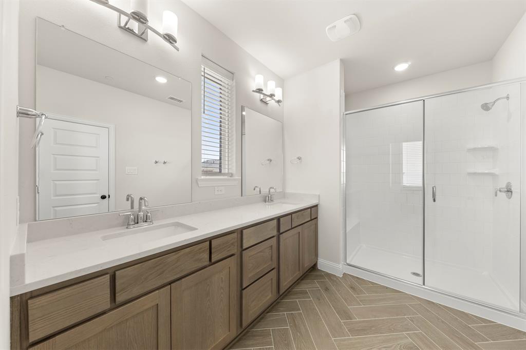 3900 Keya Drive Prosper, TX 75078 - Photo 31 of 36 a bathroom with a double vanity sink mirror and shower
