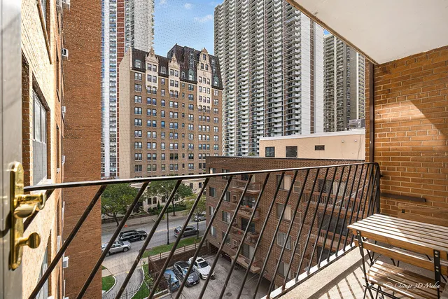 a view of balcony with a couple of cars parked in front of a house