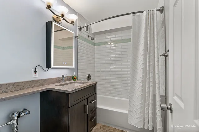 a bathroom with a granite countertop sink a mirror a vanity and a shower