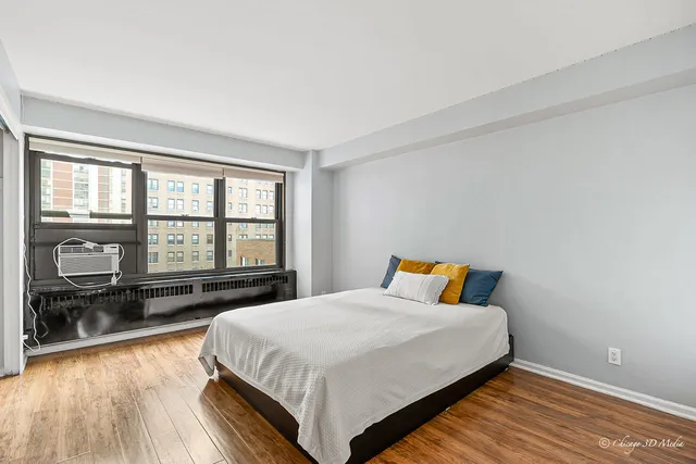 a bedroom with a bed and wooden floor