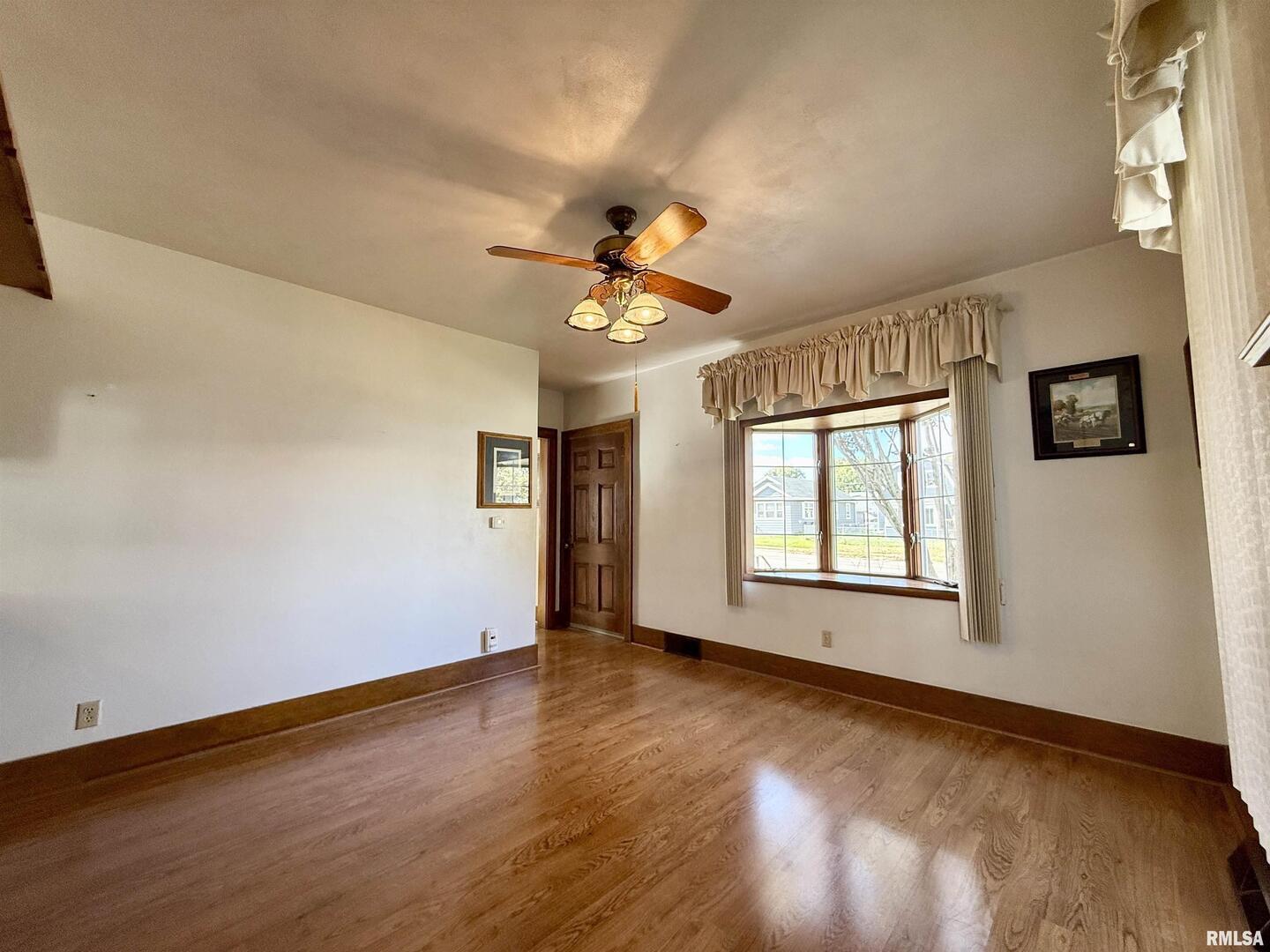 2340 7th Street East Moline, IL 61244 - Photo 4 of 26 a view of empty room with wooden floor and fan