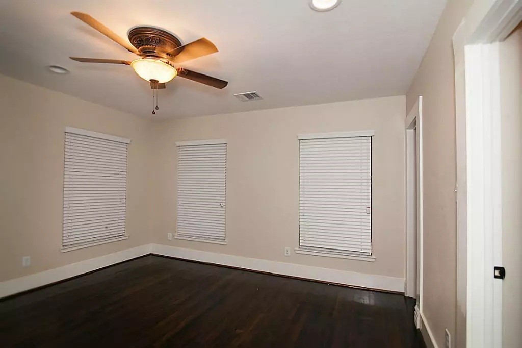 1452 Pearson Street Houston, TX 77023 - Photo 11 of 13 an empty room with wooden floor chandelier fan and windows