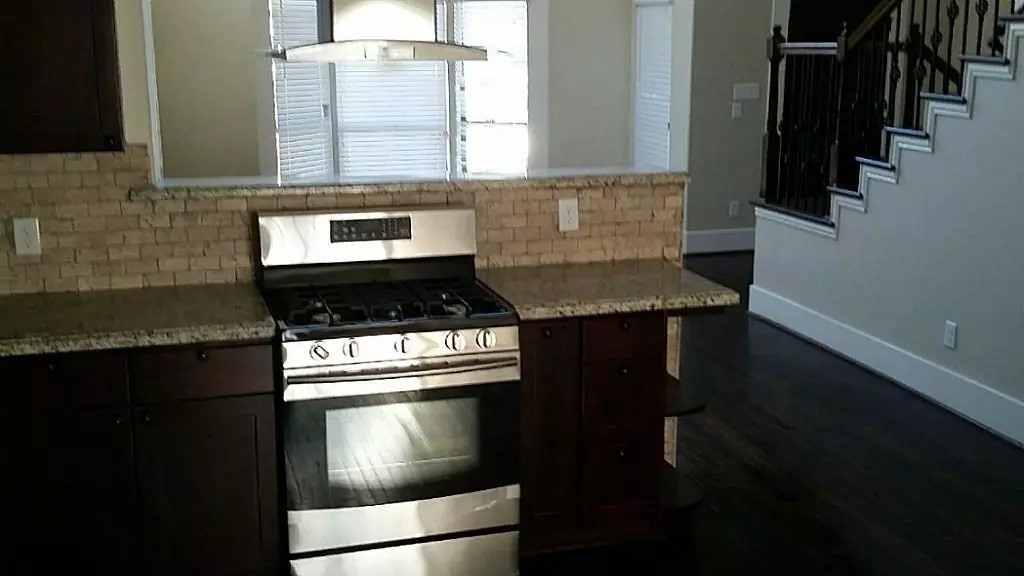 1452 Pearson Street Houston, TX 77023 - Photo 3 of 13 a kitchen with granite countertop stainless steel appliances a stove a sink and a microwave