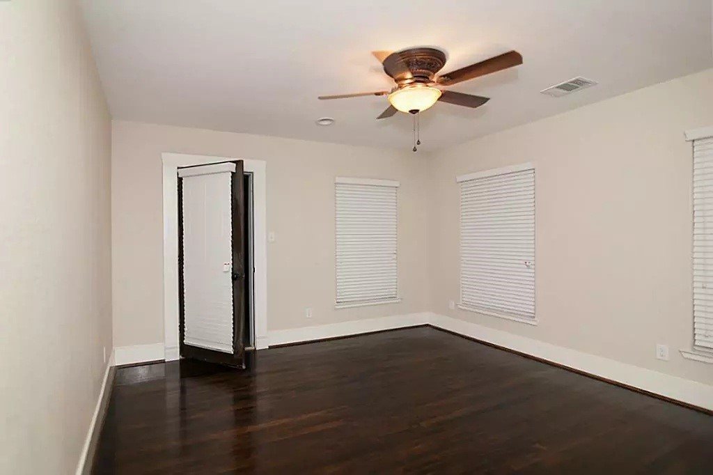 1452 Pearson Street Houston, TX 77023 - Photo 9 of 13 an empty room with wooden floor chandelier fan and windows