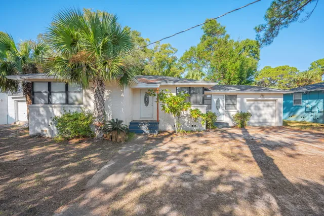 a view of a house with backyard and a tree
