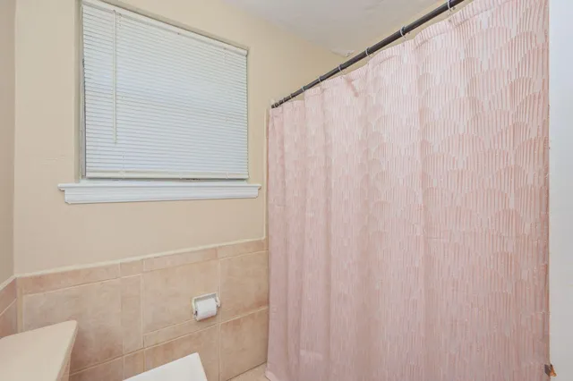 a bathroom with a shower curtain and a window