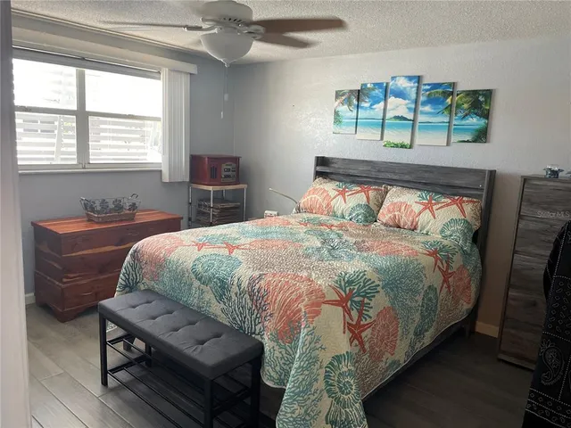 a bedroom with a bed a dresser next to a window