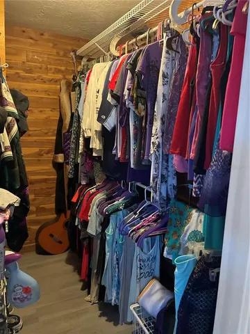 a view of walk in closet with clothes and shoes