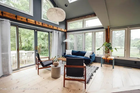 a living room with furniture potted plant and a large window