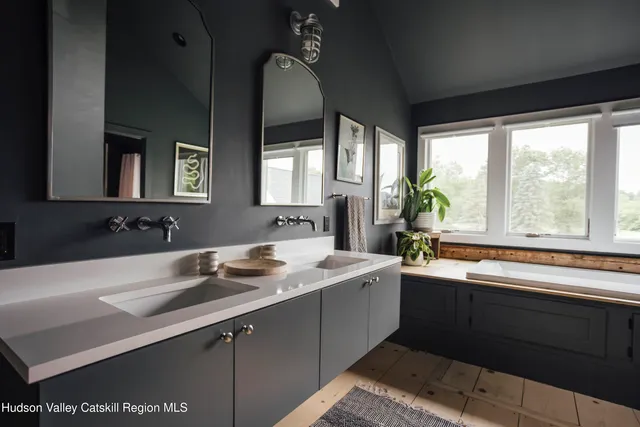 a large kitchen with kitchen island a large window a sink and stainless steel appliances