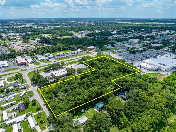 an aerial view of residential houses with outdoor space and trees