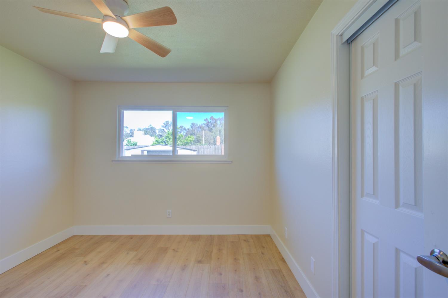 1673 Sacramento Drive Merced, CA 95348 - Photo 23 of 35 a view of empty room with wooden floor and fan