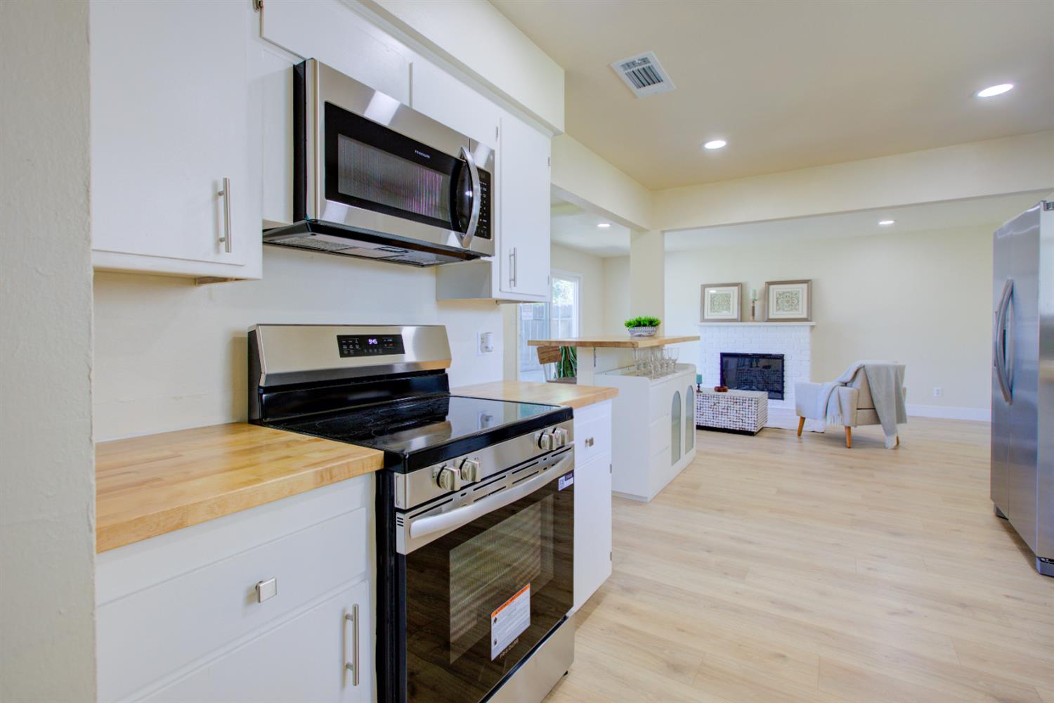 1673 Sacramento Drive Merced, CA 95348 - Photo 3 of 35 a kitchen with stainless steel appliances a stove microwave and sink