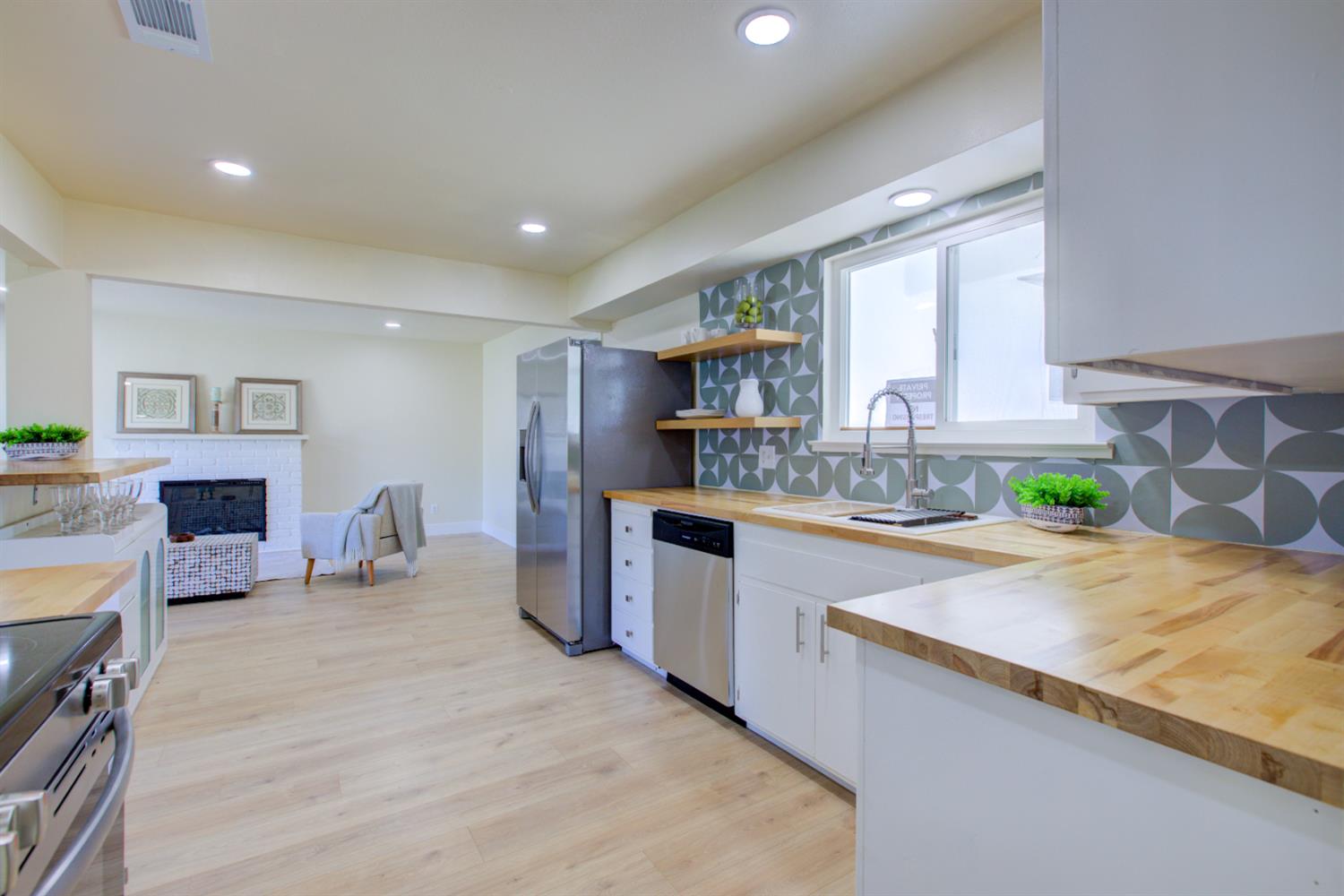 1673 Sacramento Drive Merced, CA 95348 - Photo 5 of 35 a kitchen with stainless steel appliances granite countertop a sink counter space and cabinets