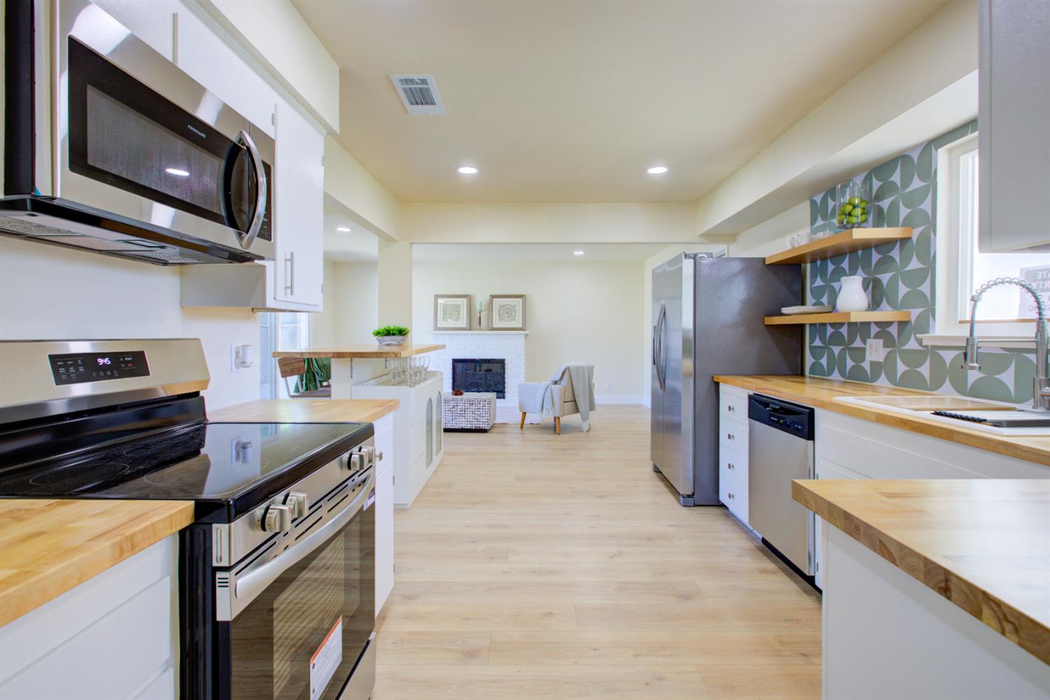 1673 Sacramento Drive Merced, CA 95348 - Photo 6 of 35 a kitchen with stainless steel appliances granite countertop a stove a sink and a microwave