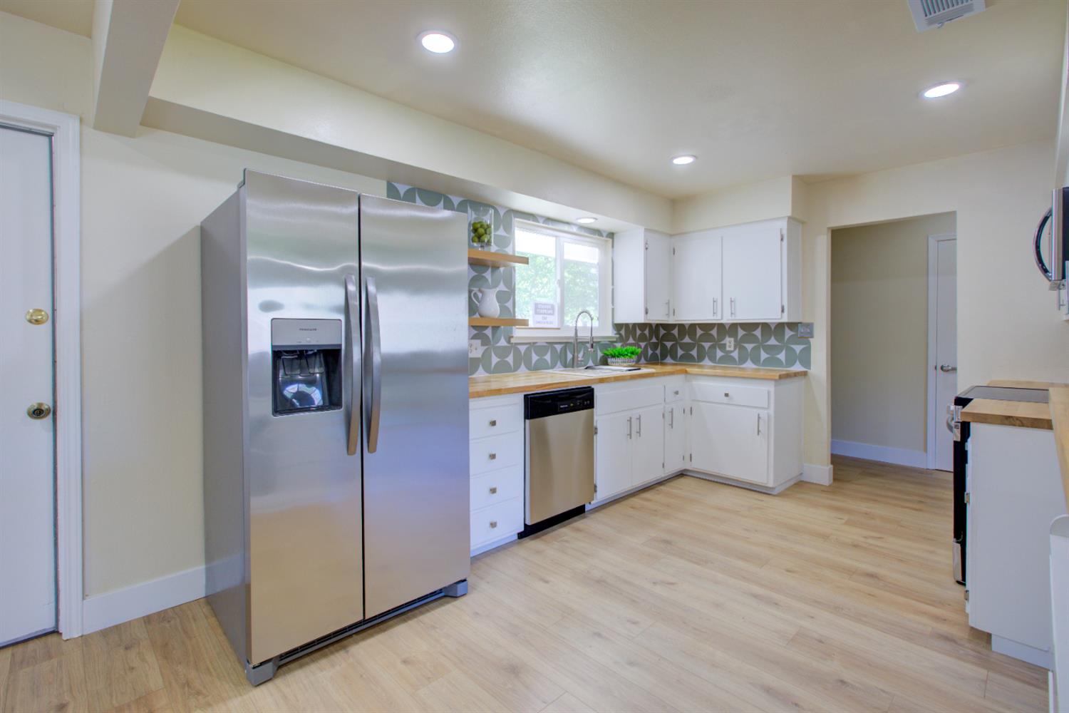 1673 Sacramento Drive Merced, CA 95348 - Photo 9 of 35 a kitchen with stainless steel appliances granite countertop a refrigerator and a stove top oven