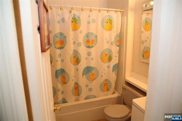 a bathroom with a toilet and shower curtain