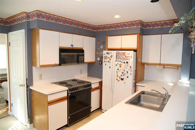 a kitchen with granite countertop a refrigerator a stove and a sink
