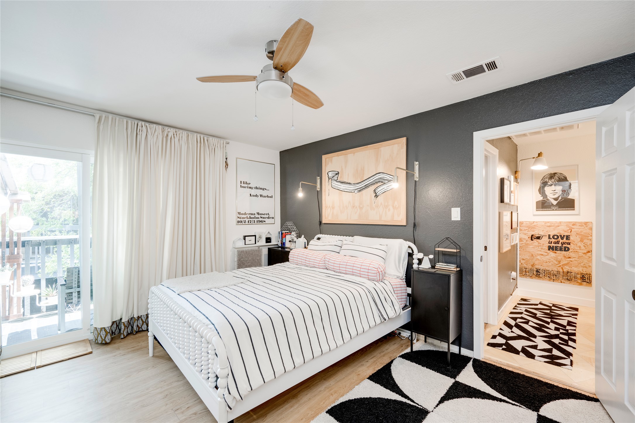 3627 Menchaca Road, Unit 214 Austin, TX 78704 - Photo 14 of 28 Sun-filled bedroom featuring a private balcony and light wood-tone flooring.