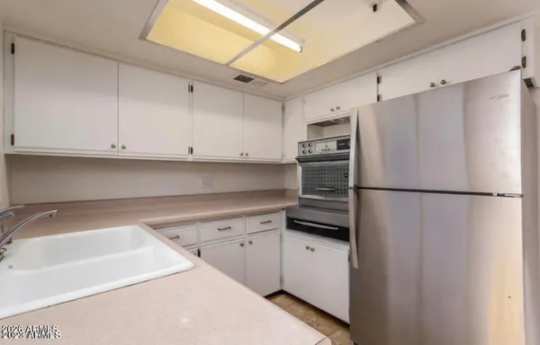 a kitchen with a refrigerator sink and cabinets