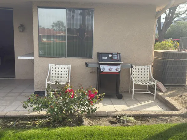 a view of a patio with table and chairs potted plants and palm tree