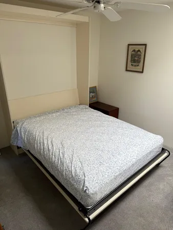 a bed sitting in a bedroom next to a window