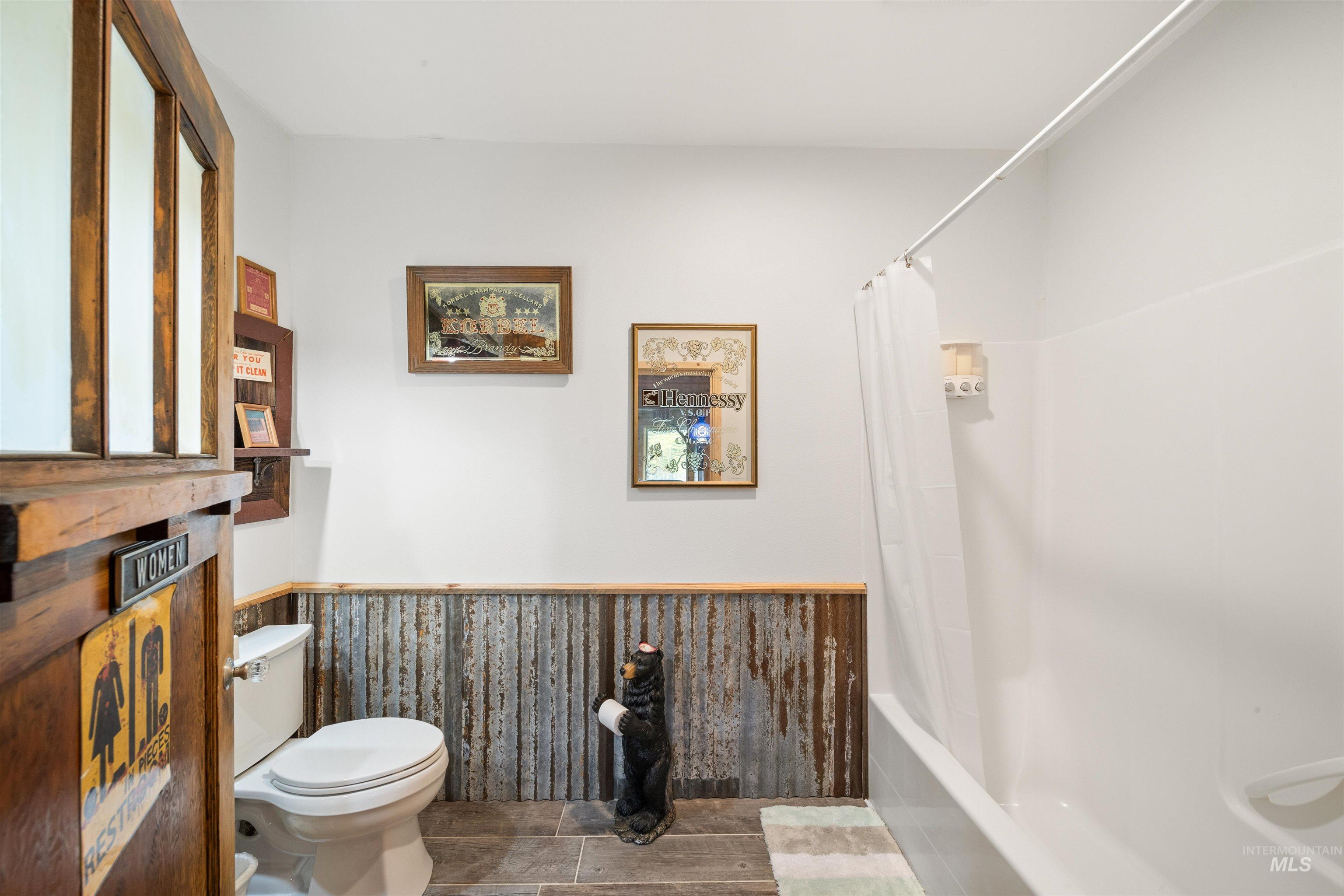 643 Adams Road Orofino, ID 83544 - Photo 32 of 50 Bathroom with wainscoting and shower / tub combo