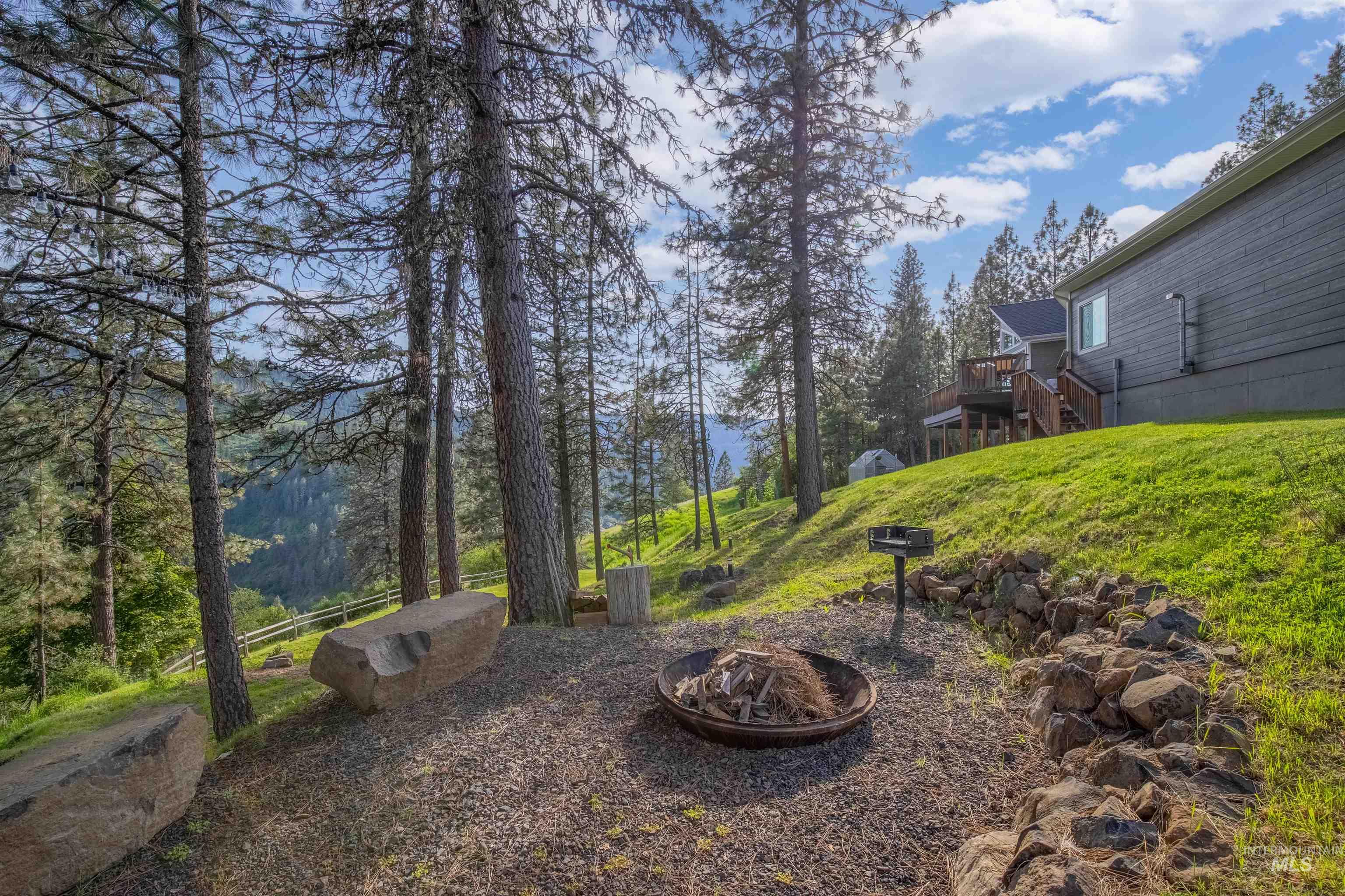 643 Adams Road Orofino, ID 83544 - Photo 39 of 50 View of yard with a wooden deck and an outdoor fire pit