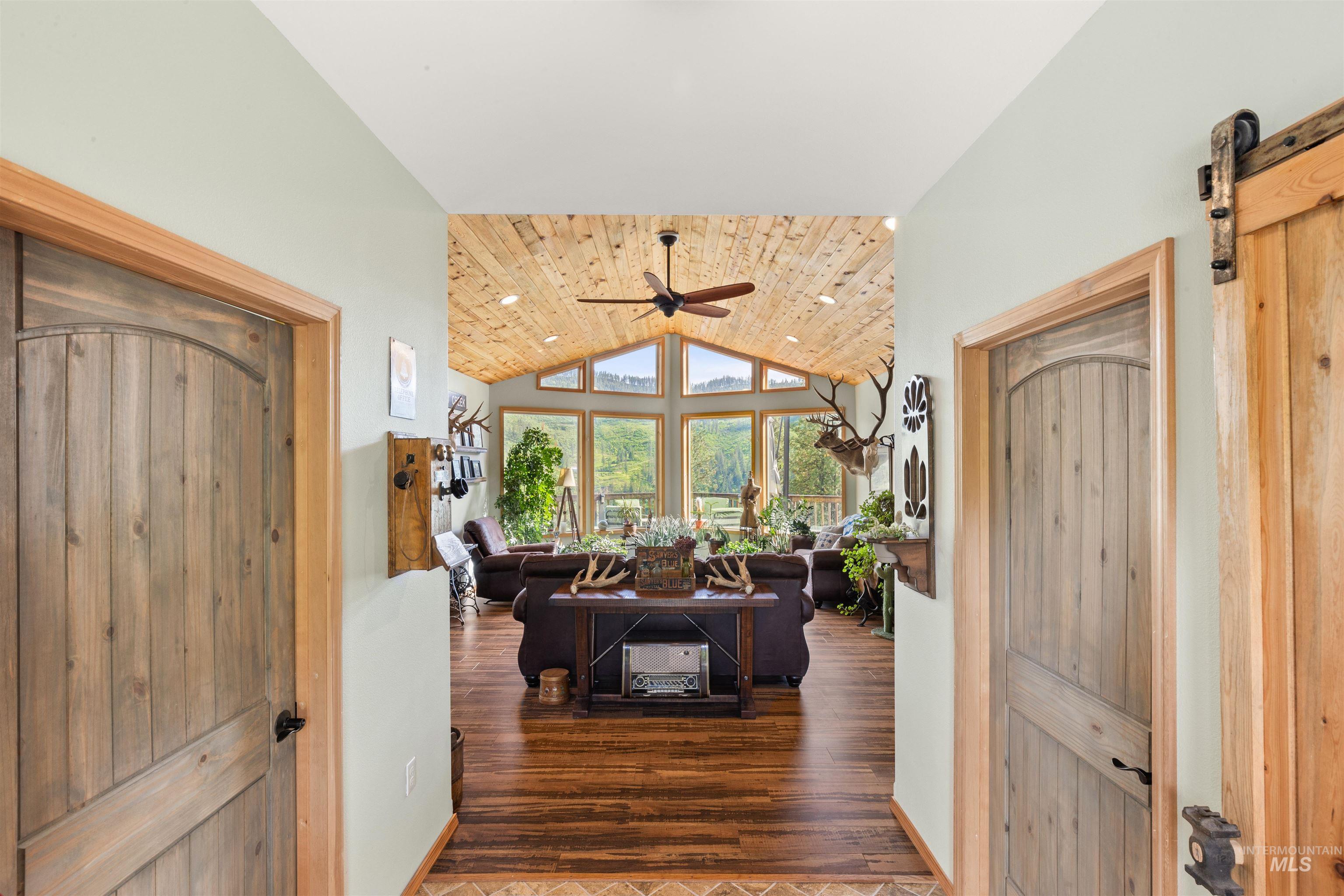 643 Adams Road Orofino, ID 83544 - Photo 4 of 50 Corridor with a vaulted wooden ceiling, a barn door, wood finished floors, and recessed lighting