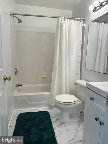 a bathroom with a sink a toilet a shower curtain and a bath tub