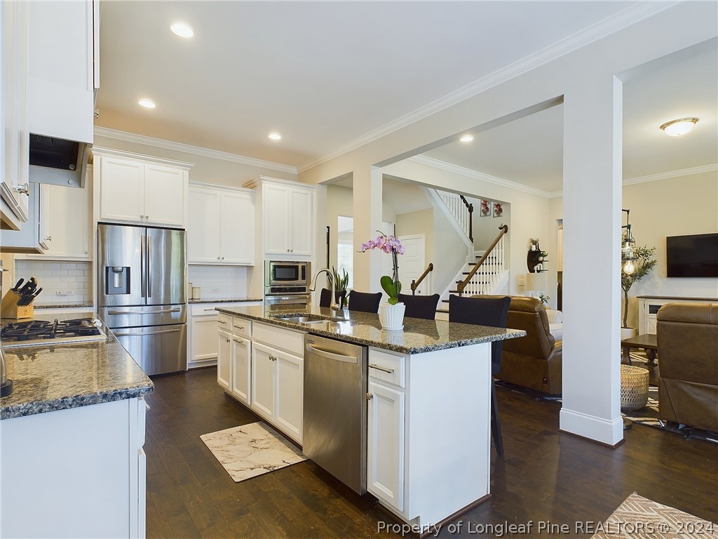 4001 Banks Stone Drive Raleigh, NC 27603 - Photo 11 of 50 a kitchen with stainless steel appliances granite countertop a sink stove and refrigerator
