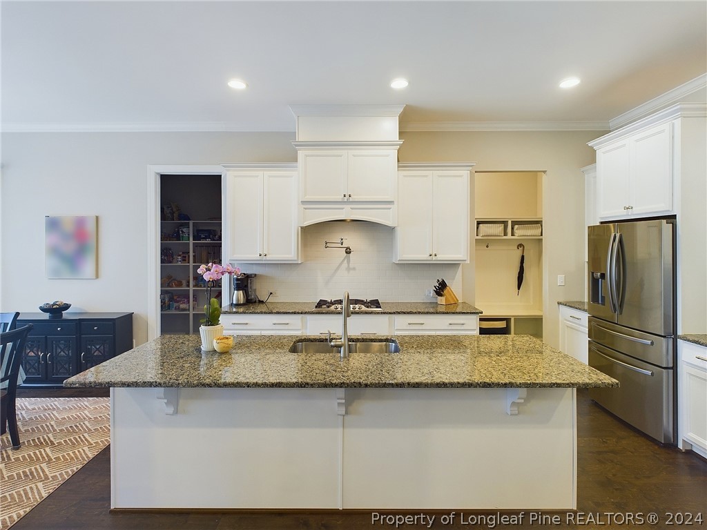 4001 Banks Stone Drive Raleigh, NC 27603 - Photo 13 of 50 a kitchen with kitchen island granite countertop a sink a center island stainless steel appliances and cabinets