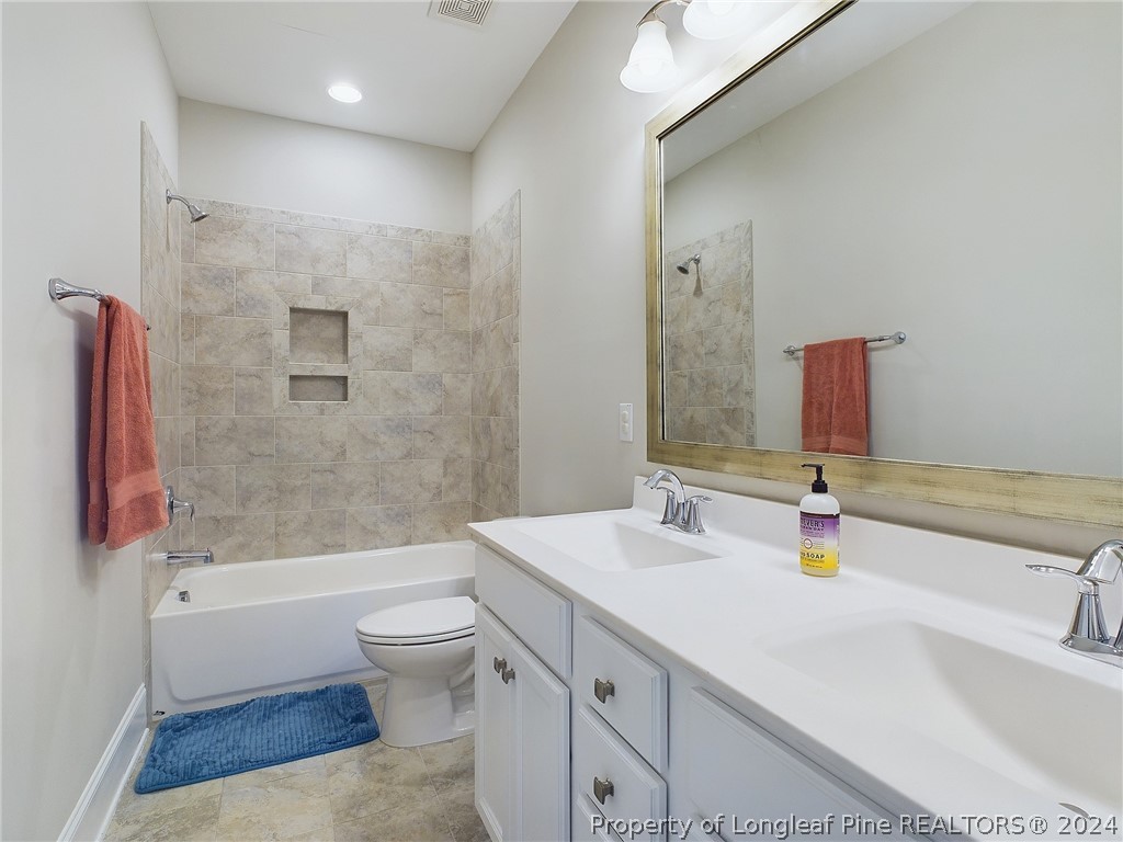 4001 Banks Stone Drive Raleigh, NC 27603 - Photo 29 of 50 a bathroom with a sink a toilet and a large mirror