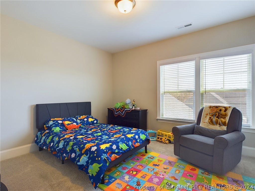 4001 Banks Stone Drive Raleigh, NC 27603 - Photo 32 of 50 a bedroom with a bed and a couch in it