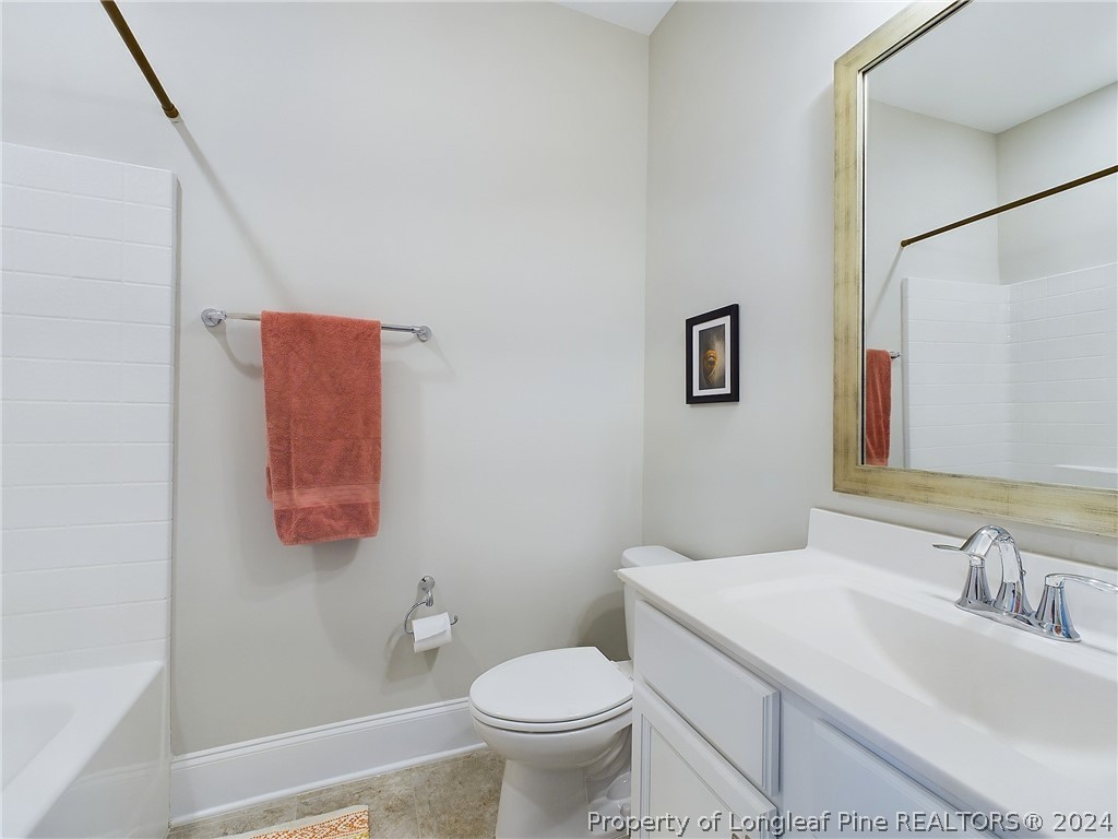 4001 Banks Stone Drive Raleigh, NC 27603 - Photo 35 of 50 a bathroom with a granite countertop toilet sink and mirror