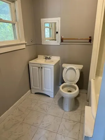 a bathroom with a toilet sink and mirror