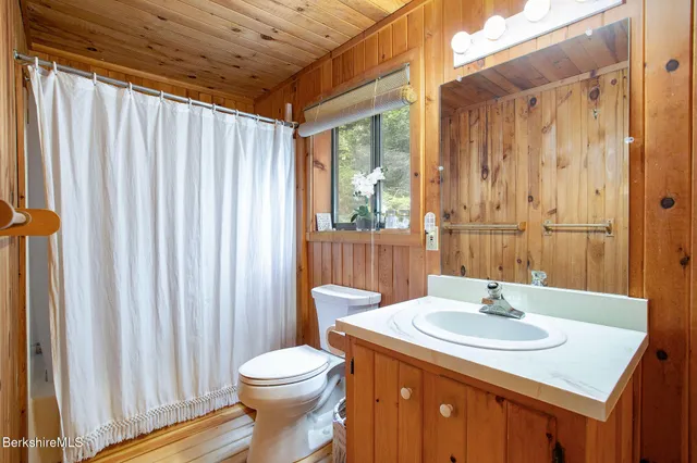 a living room with couches and a dining table with wooden floor