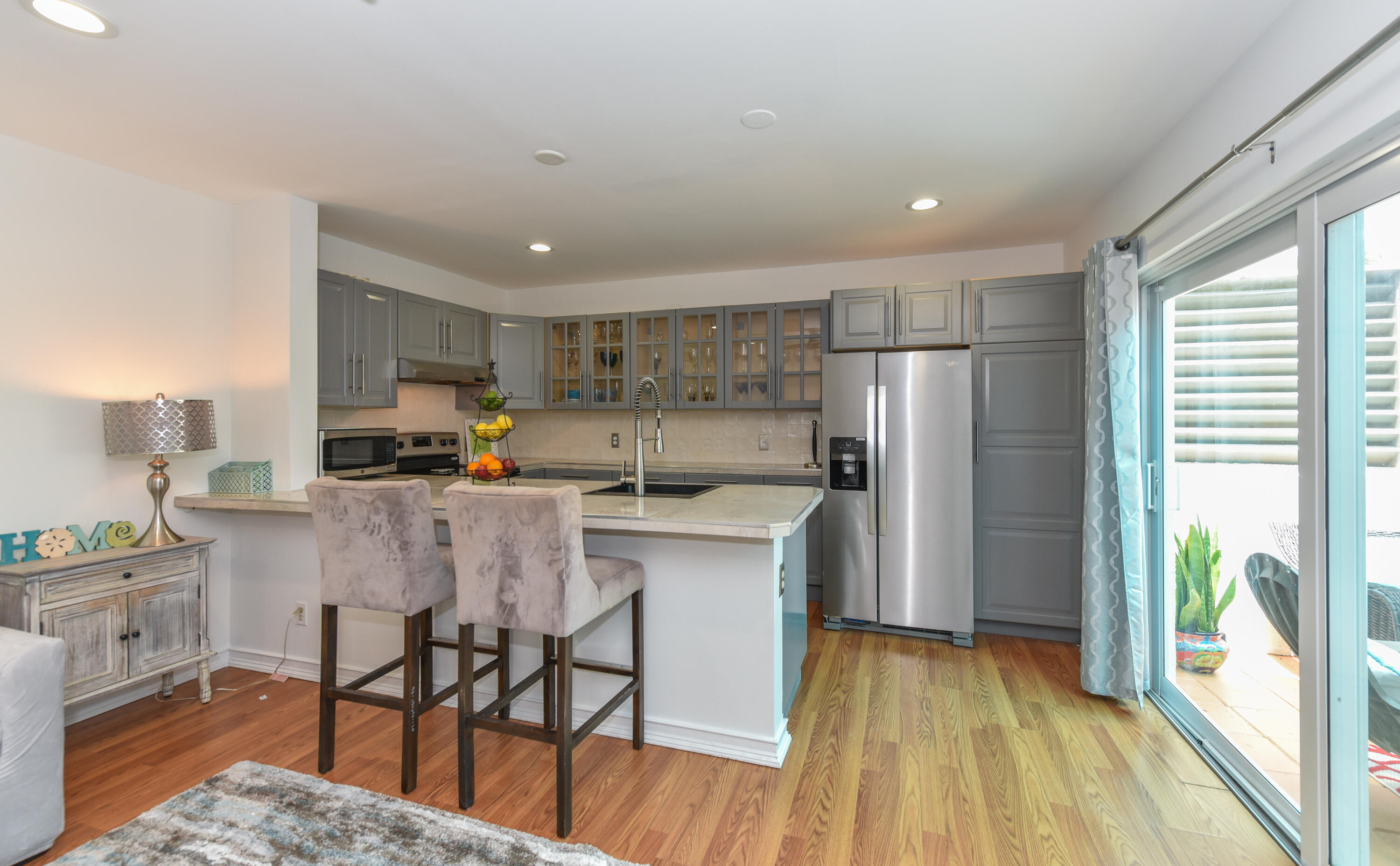 1605 Highway 1, Unit 1D Jupiter, FL 33477 - Photo 14 of 54 a kitchen with a table chairs refrigerator and microwave