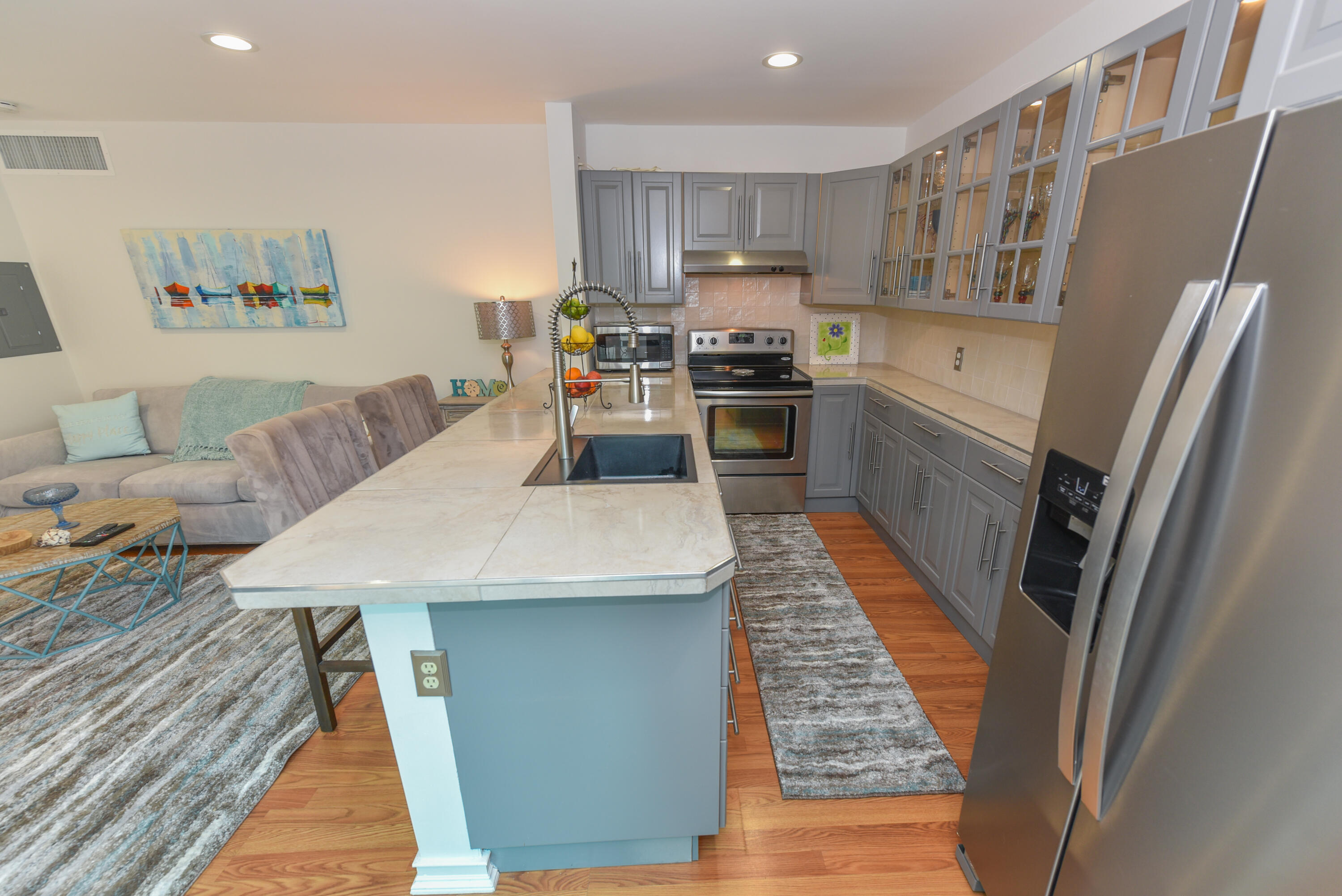 1605 Highway 1, Unit 1D Jupiter, FL 33477 - Photo 18 of 54 a kitchen with stainless steel appliances wooden floor and a refrigerator